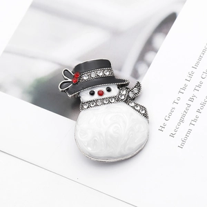Detail of a Christmas snowman brooch with white enamel, black hat, and sparkling rhinestones