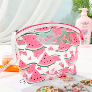 Close-up of a clear PVC watermelon pouch with pink zipper and white handle on a vanity