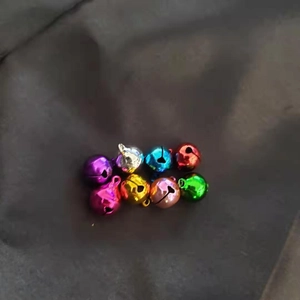 Top view of eight colorful 12mm copper bells for Christmas DIY and pet accessories