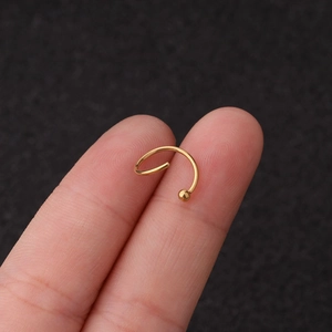 Vue rapprochée d'un earcuff en forme de C en acier inoxydable doré avec petite boule