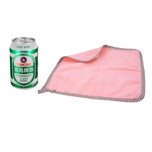 Pink pineapple texture absorbent dishcloth with brown check edge next to beer can for size