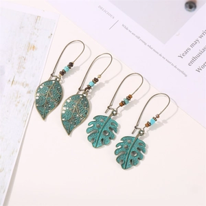 Vue détaillée de boucles d'oreilles feuilles en bronze avec perles bleu turquoise