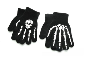 Detail of two pairs of knit gloves for kids with glow-in-the-dark skull and bone patterns