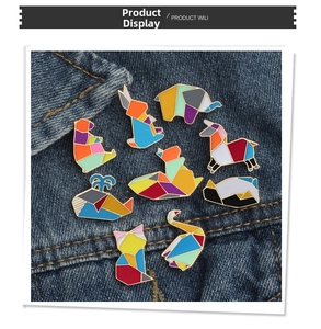 Détails de broches émaillées origami avec motifs animaux géométriques colorés sur denim