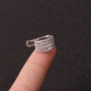 Macro view of a silver multi-layer ear cuff with tiny zircon stones on fingertips