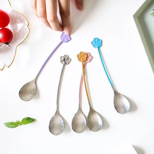 Detail shot of colorful flower-shaped stainless steel spoons for coffee and dessert
