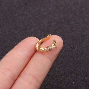 Gold twisted ear cuff with micro-pave cubic zirconia on a dark textured background