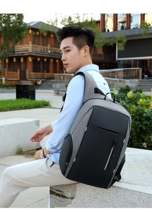 Zaino porta PC in tessuto grigio con strisce riflettenti su modello in ambiente esterno