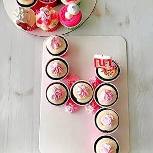 Cupcakes rosa e bianchi con farfalle decorative e candela numero 4 in pirottini dorati