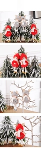 Detail of plush Christmas elk figurines in red and grey hanging on a festive holiday tree