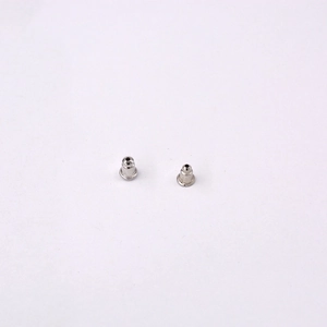 Close-up of silver metal bullet clutch earring backs on a clean white background