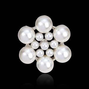Detailed view of pearl and rhinestone floral brooch with silver base on black background