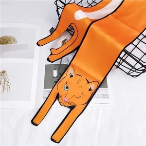 Detail of an orange silk scarf with cartoon cat patterns on a black decorative basket