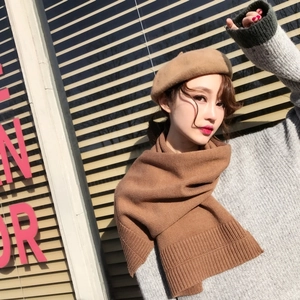 Detailed knit texture of a brown winter scarf worn by a model in a stylish look