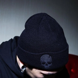 Men's black punk knit beanie with skull embroidery in a street style studio shot