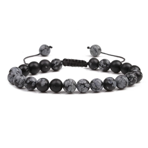 Macro view of beaded bracelet with black and spotted stones on adjustable woven cord