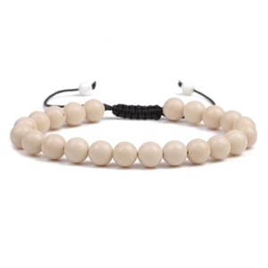 Adjustable woven bracelet featuring natural off-white round beads and a braided black cord