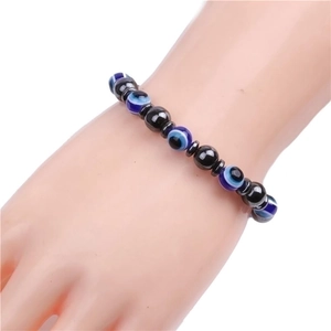 Detail of 8mm evil eye and black magnetic beads on a minimalist wrist display