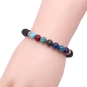 Lava stone bead bracelet with colorful gemstones and golden spacers on a wrist