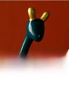 Detailansicht des goldenen Geweihs an einer dunkelgrünen Keramik-Giraffenfigur