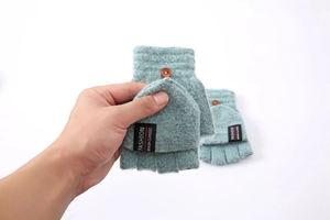 Detail of light cyan knitted flip top glove with wood button and fashion label