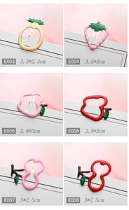 Detail of colorful fruit-shaped hair clips including sizes for strawberry and pineapple