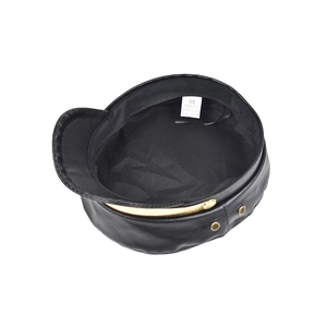 Dettaglio del cappello baker boy in pelle PU nera con catena dorata e fibbia in metallo