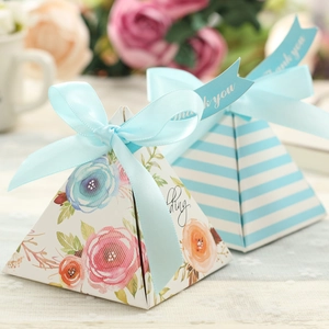 Pink and floral pyramid candy boxes with light blue ribbons for wedding party favors