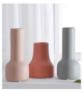 Primer plano de tres jarrones Morandi de cerámica mate en rosa, rojo y gris hogar