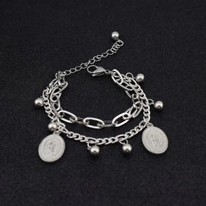 Detail of silver double-layered bracelet with virgin mary charms and small beads