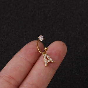 Détail macro d'une boucle d'oreille en C en acier doré avec pendentif lettre A en zircon