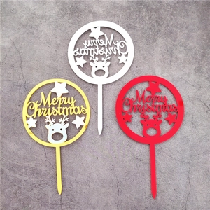 Macro detail of red, gold, and white acrylic Merry Christmas cake toppers with reindeer