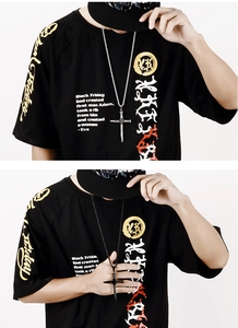 Close-up of stainless steel cross pendant necklace on a streetwear t-shirt model