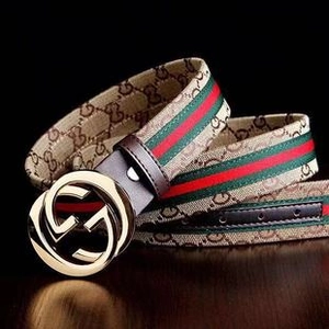 Close-up of golden double-G buckle with red and green stripe detail on canvas belt