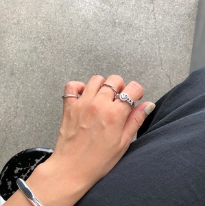 Detail of 925 sterling silver smile face chain ring and minimalist textured band set