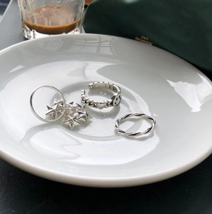 Detailed view of 925 silver ring set with stars, smiley face chain and rope band
