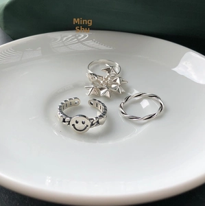 Detail of 925 sterling silver ring set with smile face, star and braided texture