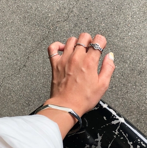 Detailed view of 925 sterling silver smile ring and bracelet set on hand outdoors