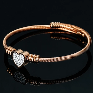 Close-up of rose gold cable wire bracelet with heart pendant and sparkling rhinestones