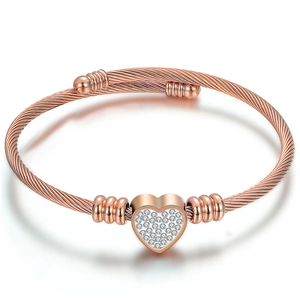 Close-up of rose gold twisted cable bracelet with a sparkling crystal heart charm