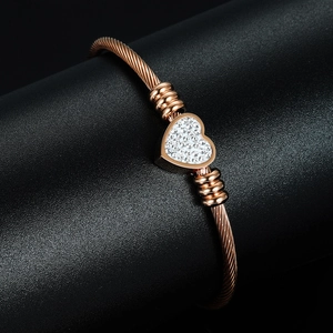 Detail of rose gold cable wire bracelet featuring a crystal-encrusted heart charm