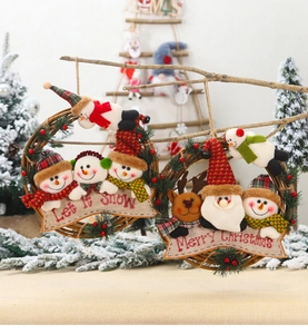 Close-up of a Christmas rattan wreath with a cartoon snowman and Let It Snow wooden sign