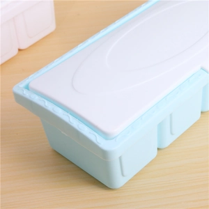 Light blue 4-compartment seasoning box with white textured lid on a wooden table