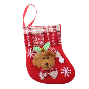 Detail of red Christmas stocking with 3D plush bear head, golden bell and snowflake pattern