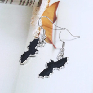 Detailed close-up of black enamel bat earrings with silver-tone fishhook wires