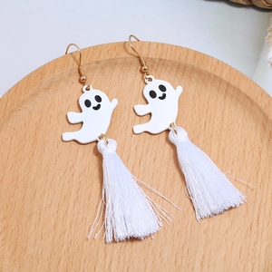 Detail of Halloween ghost earrings with white tassels and gold hooks on wood tray