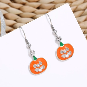 Detailed view of Halloween pumpkin earrings in orange enamel on a white display card