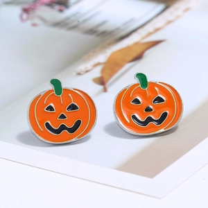 Macro detail of classic orange pumpkin earrings with colorful enamel on metal base