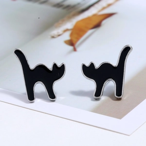 Detailed close-up of creative black cat enamel stud earrings with silver metal outlines