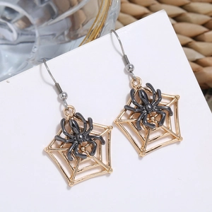 Detail of gothic spider web earrings featuring a black spider on a golden alloy web